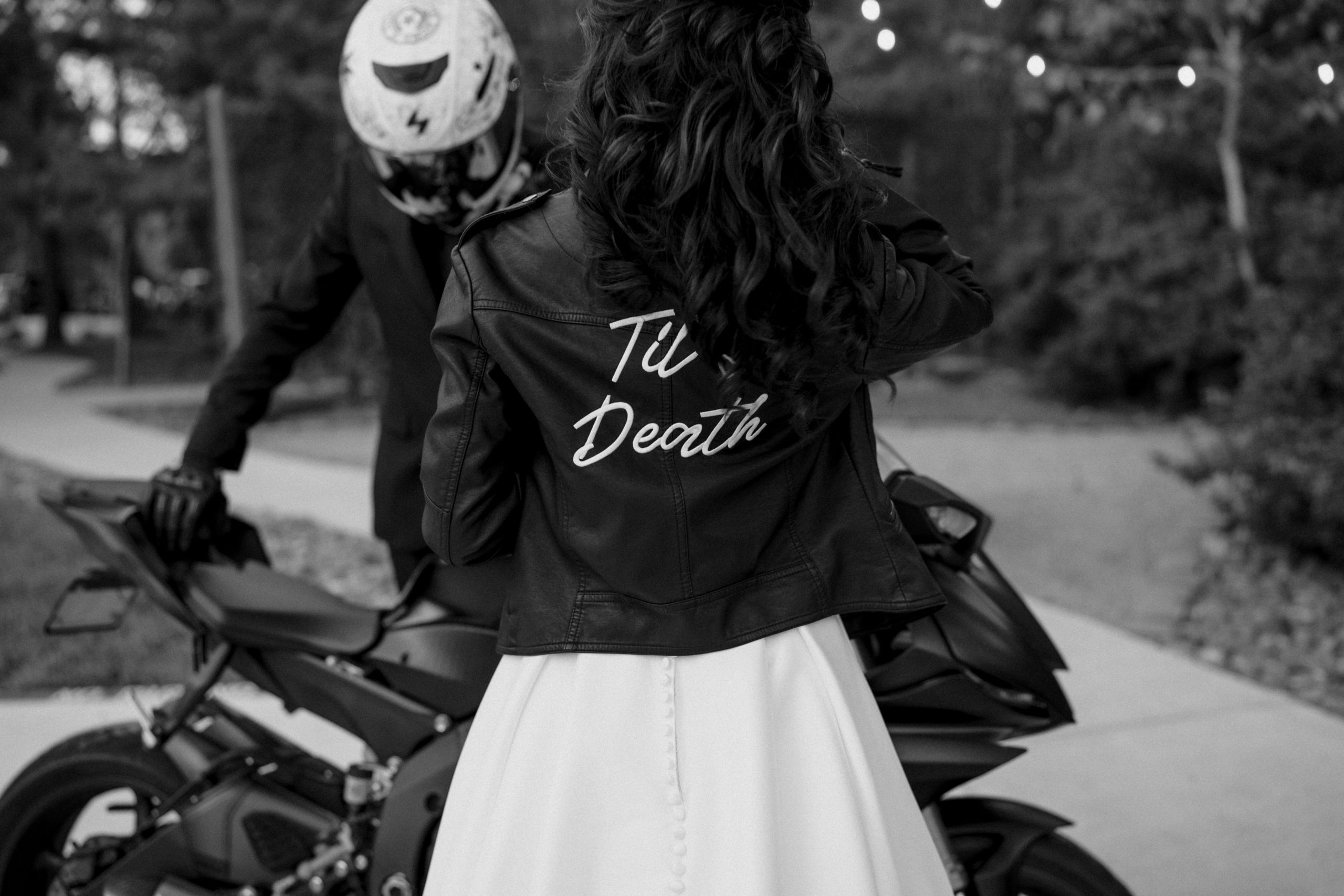 bride wearing biker jacket next to a motorcycle