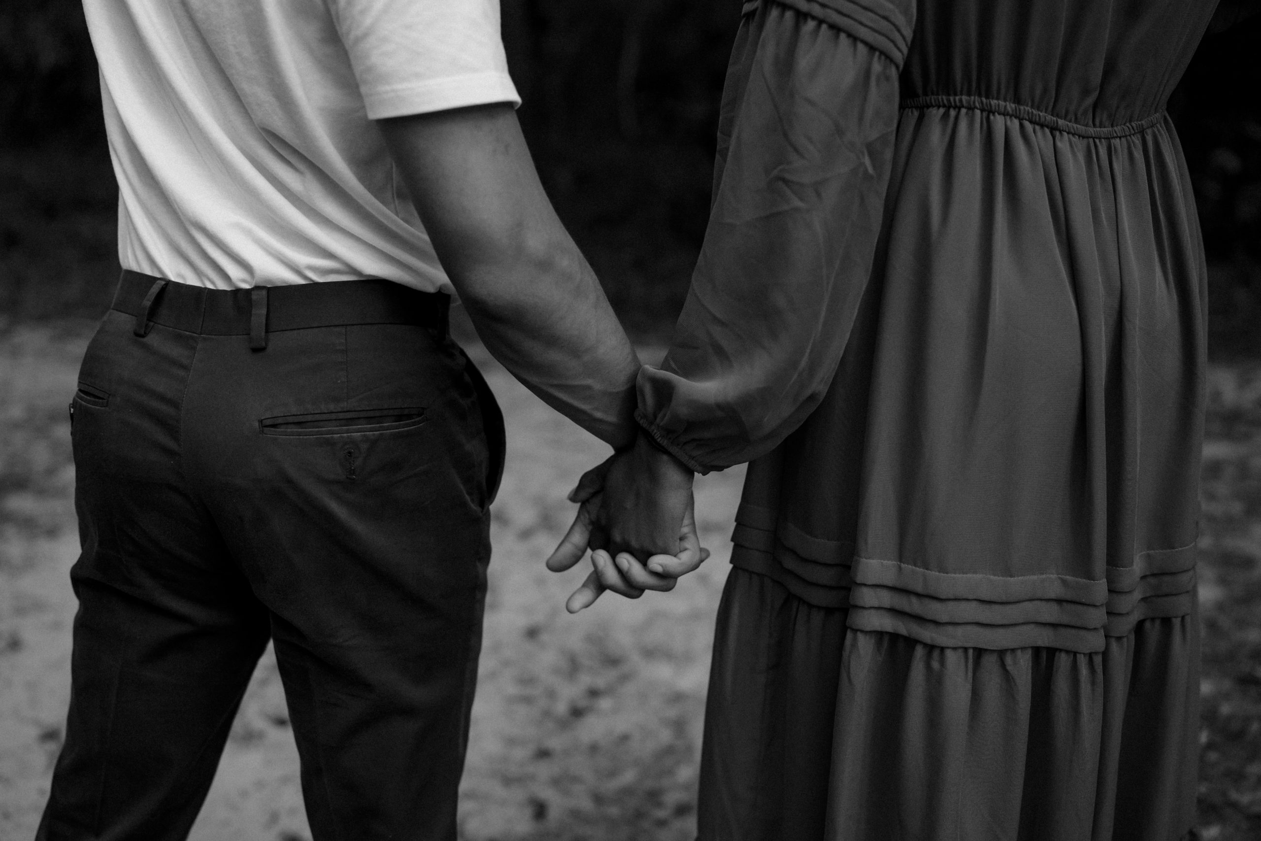 A black and white picture of a Couple holding hands at their engagement session done by Angelina Loreta Photography