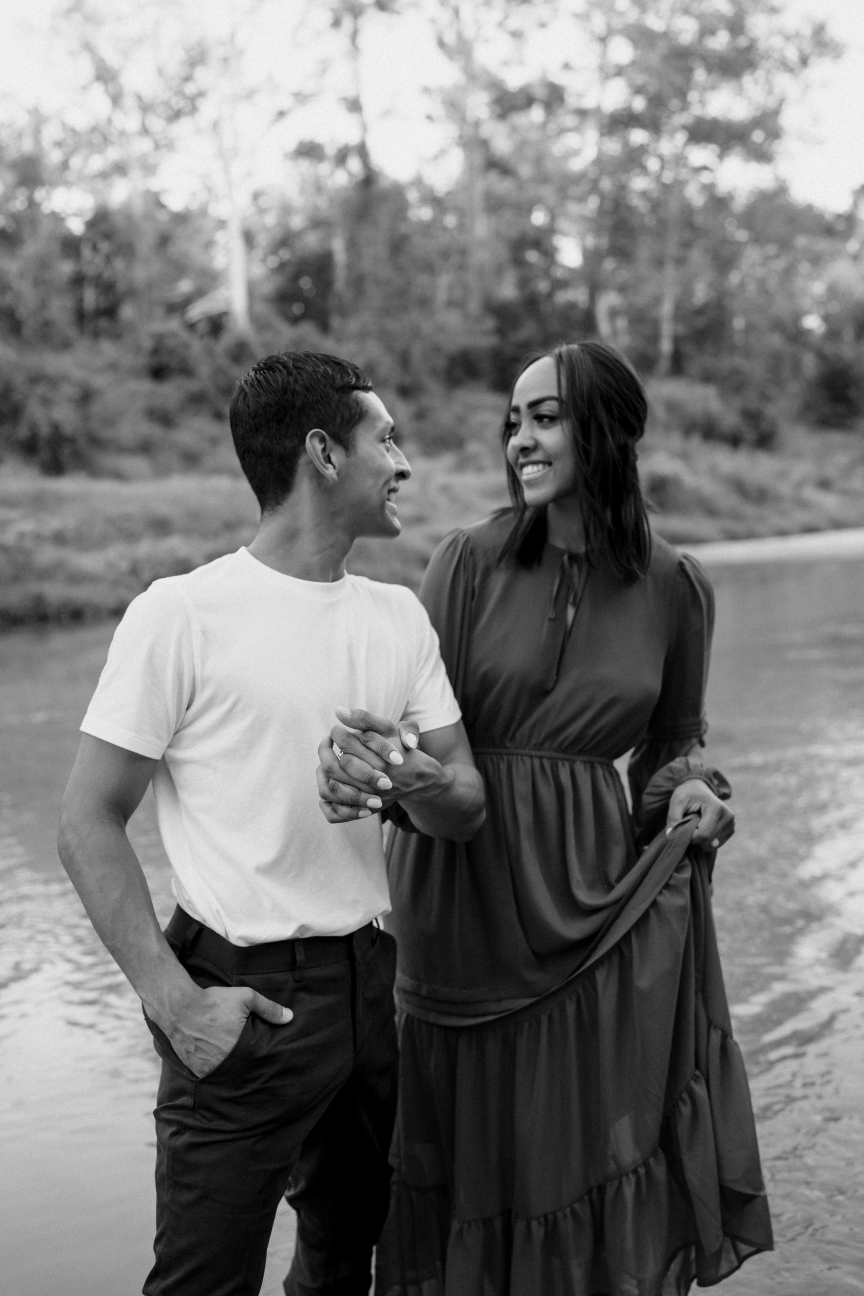 A black and white photo of a couple looking at each other for their engagement session done by Angelina Loreta Photography in Houston, Texas.