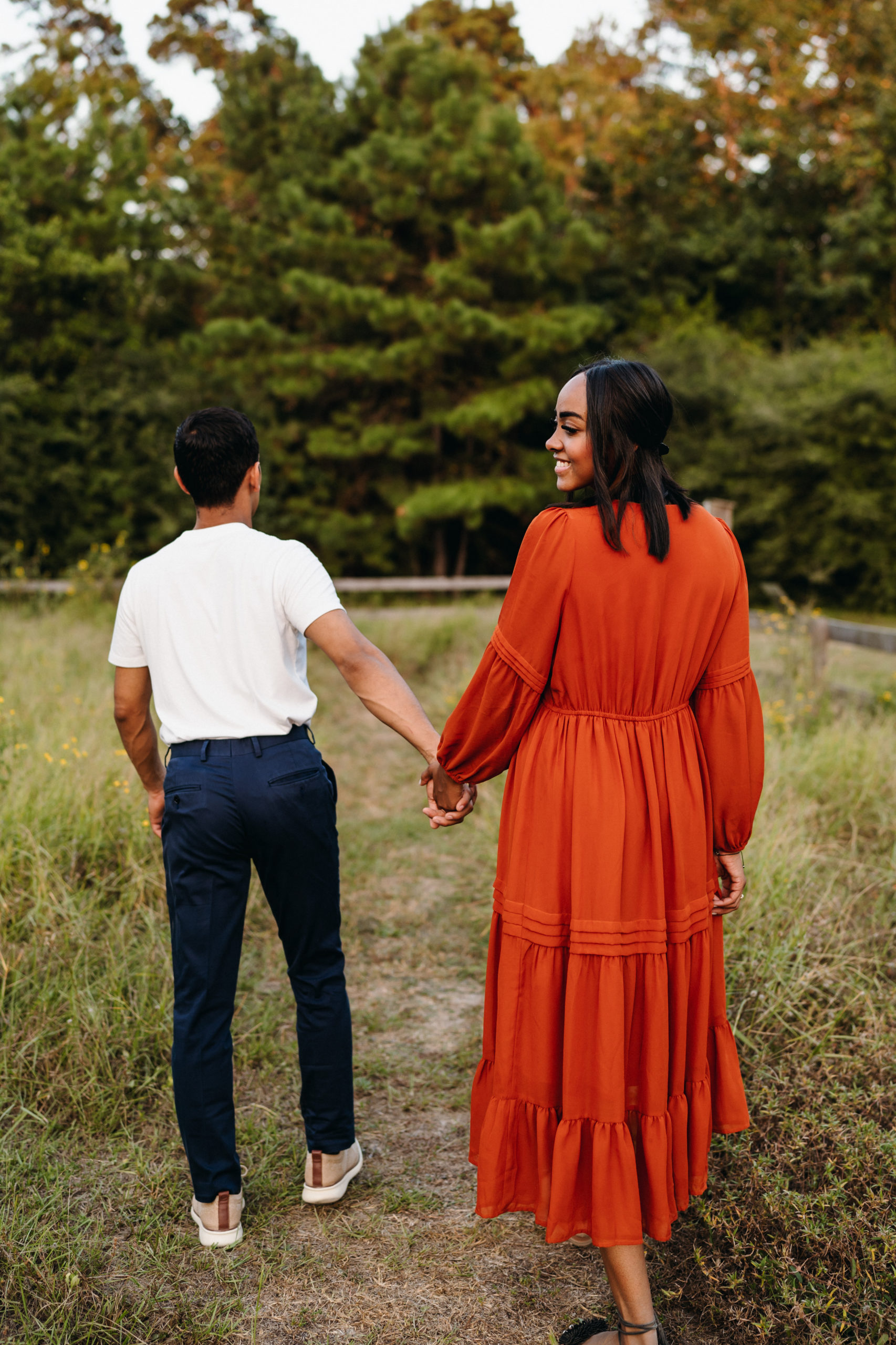 A couple walking in a garden for their engagement pictures done by Angelina Loreta Photography in Houston, Texas.