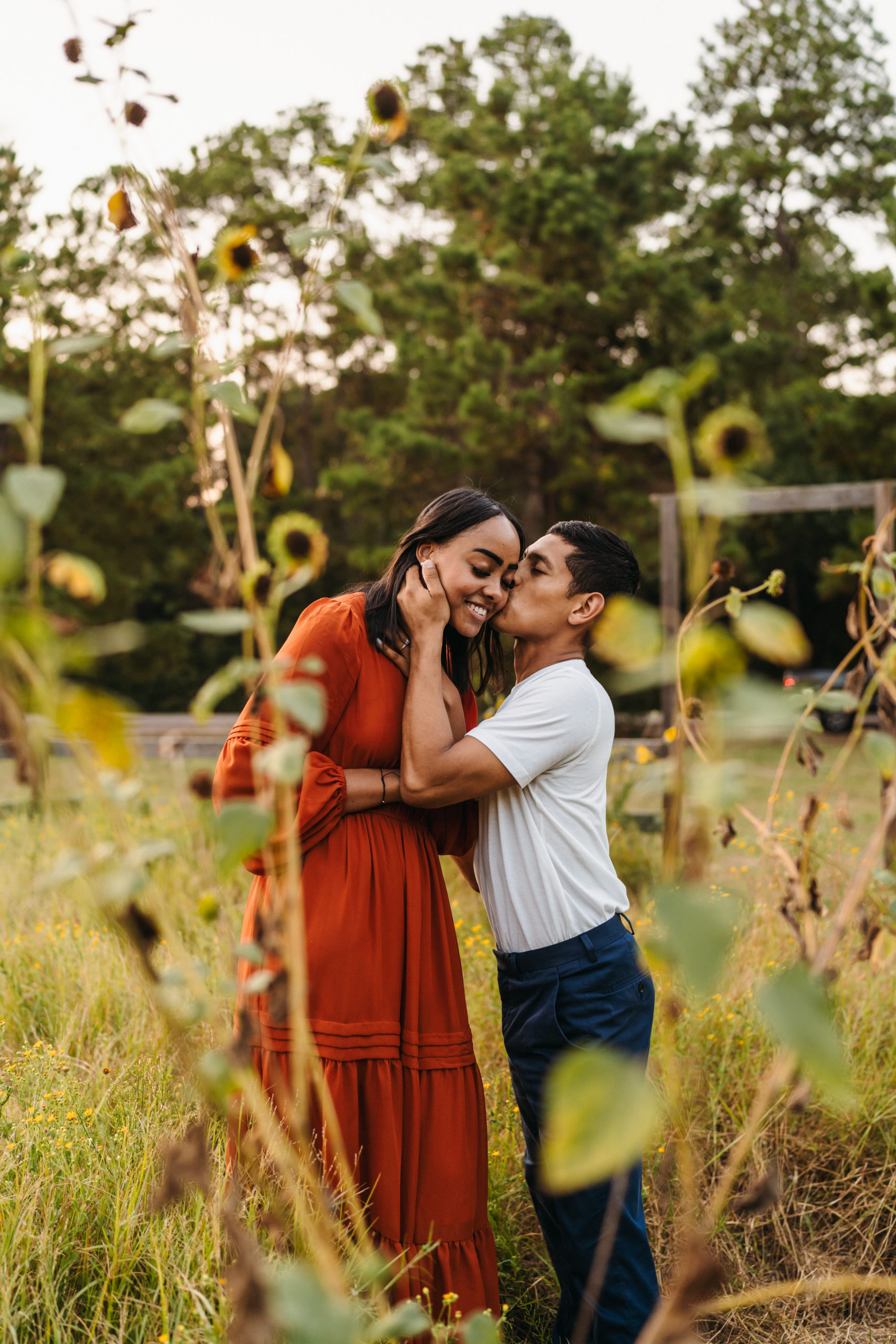 A couple surrounded by wildflowers for their engagement pictures done by angelina loreta photography in houston, texas.