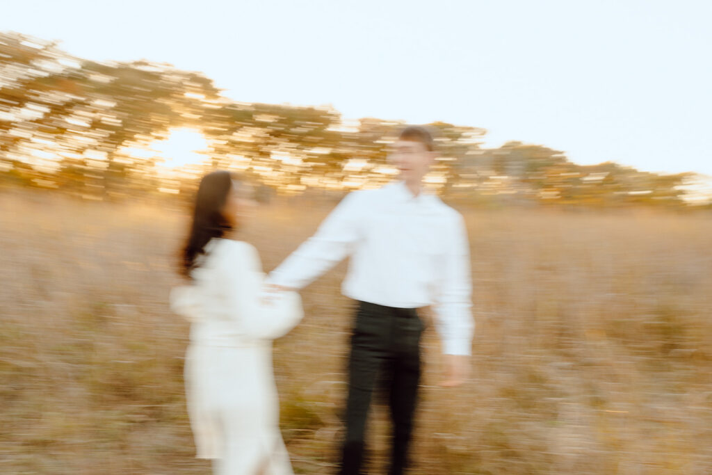 romantic and candid engagement photos couple smiling and holding hands blurry couple photos