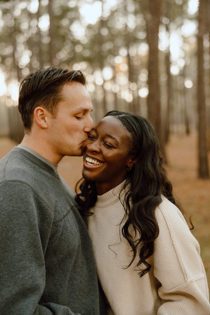 couple smiling and kissing cheek during couples photoshoot