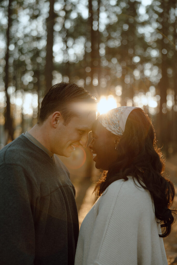 forest engagement photos during golden hour couple touching foreheads