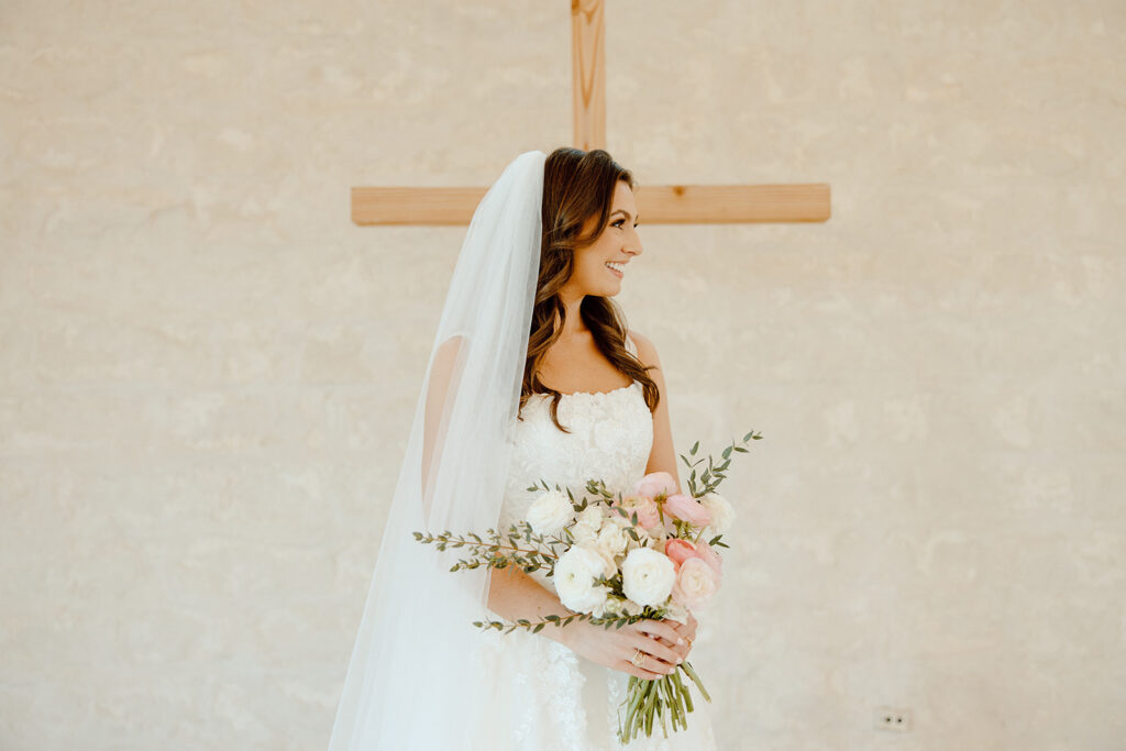 bride standing in front of cross on the altar