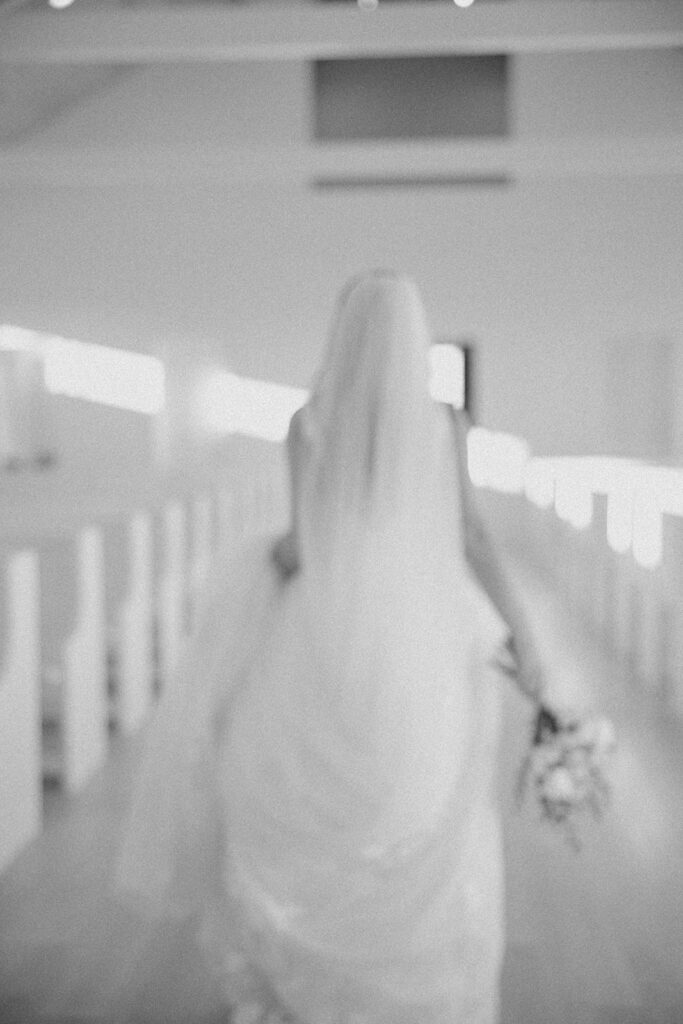 bride walking down the aisle portraits black and white