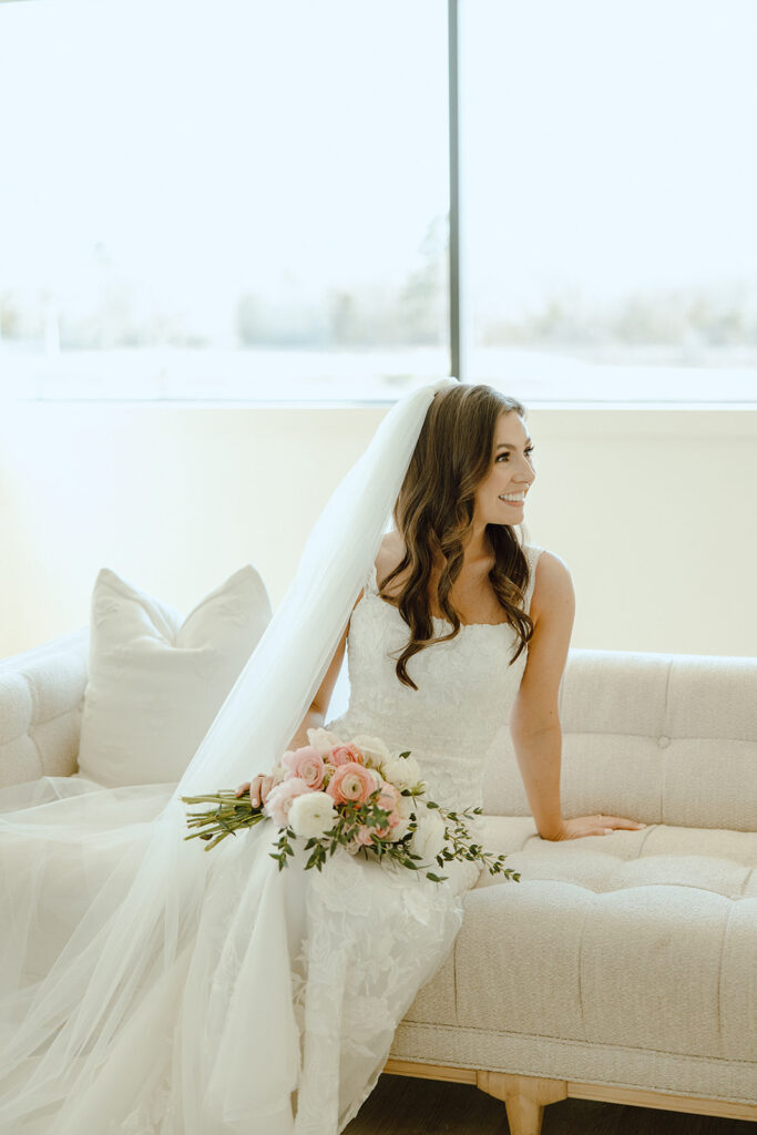 bride smiling on couch wedding portraits
