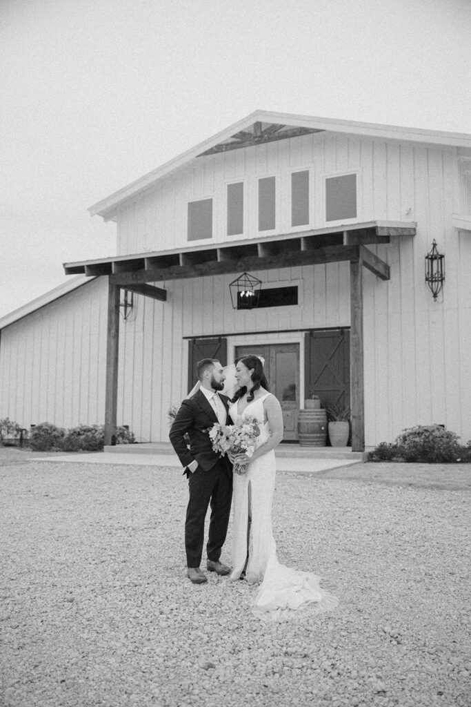 bride and groom portraits in front of barn venue