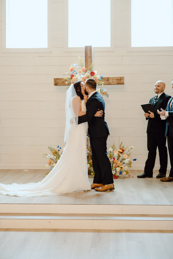 bride and groom kiss during wedding ceremony