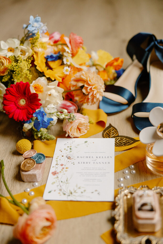 colorful yellow and red and blue wedding details flatlay