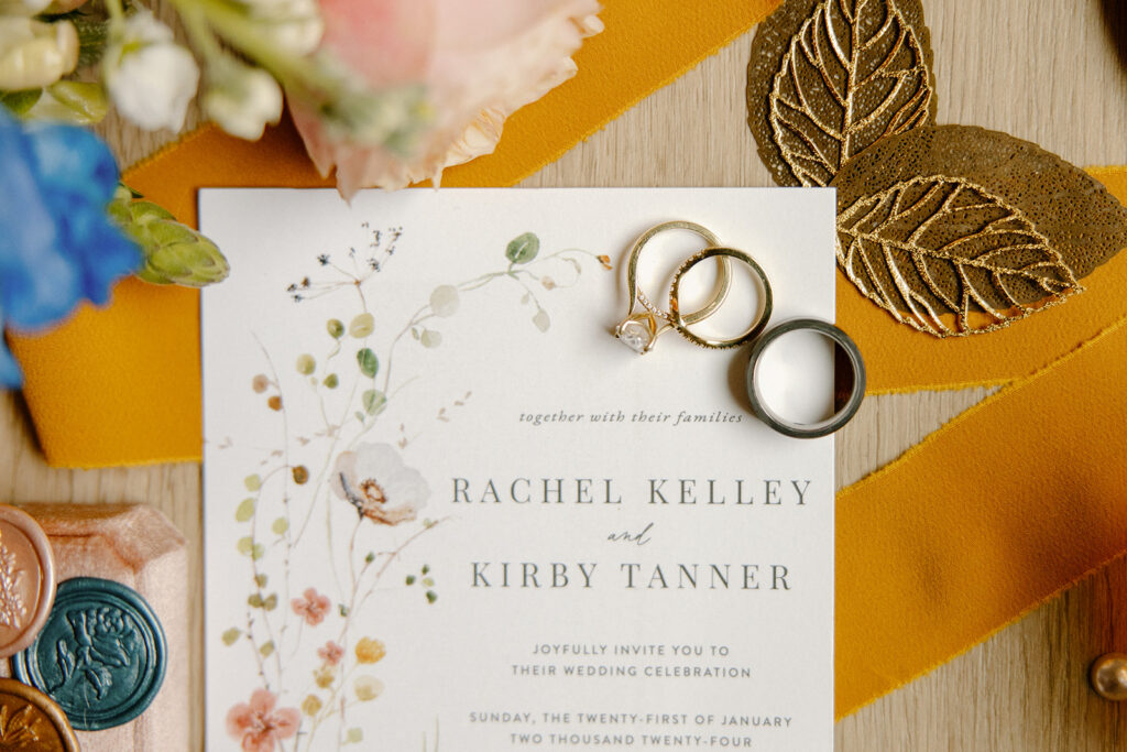 colorful wedding details rings and invitations