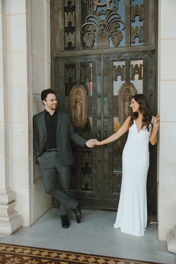 bride and groom standing in doorway bridal portraits