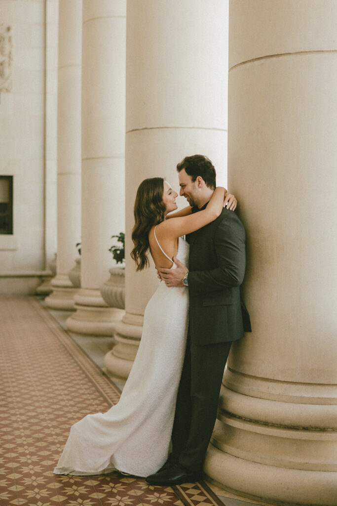 bride and groom posing in architectural building