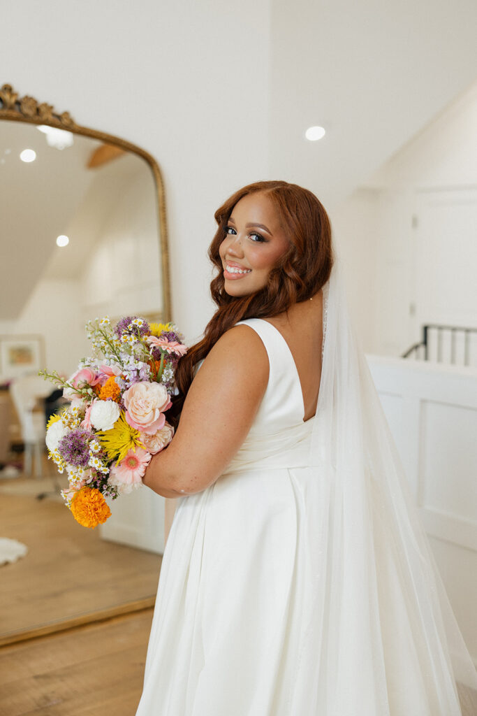 bride getting ready for ceremony with colorful bridal bouquet in hand