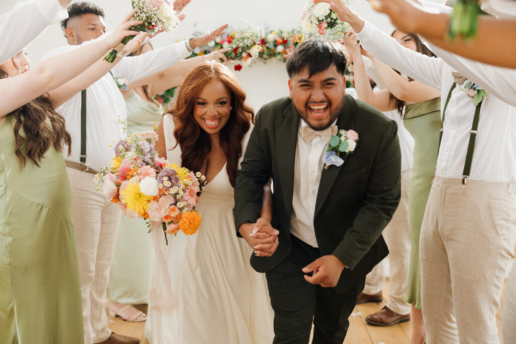 bride and groom running through bridal party tunnel