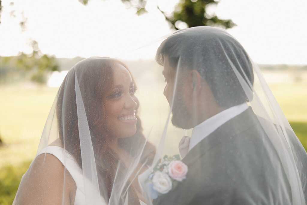 bride and groom photos underneath veil outdoors