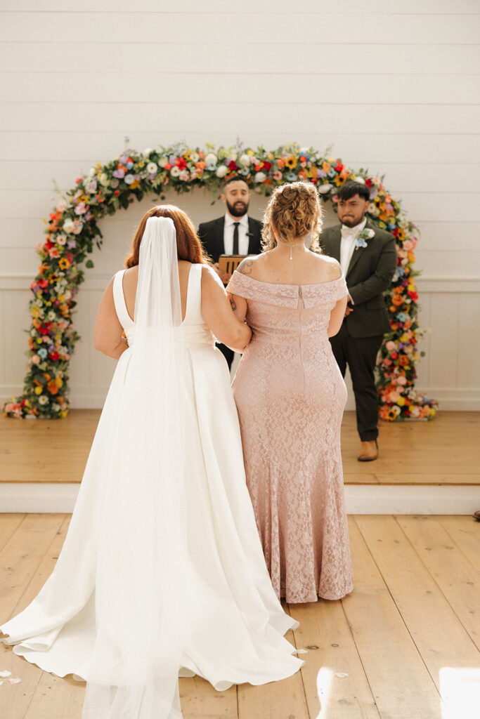 bride walking down the aisle in bright colorful wedding venue