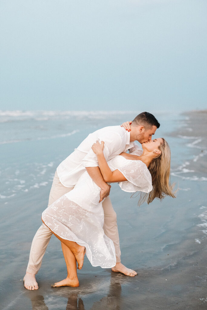 couple kissing during engagement sesison on the beach in texas