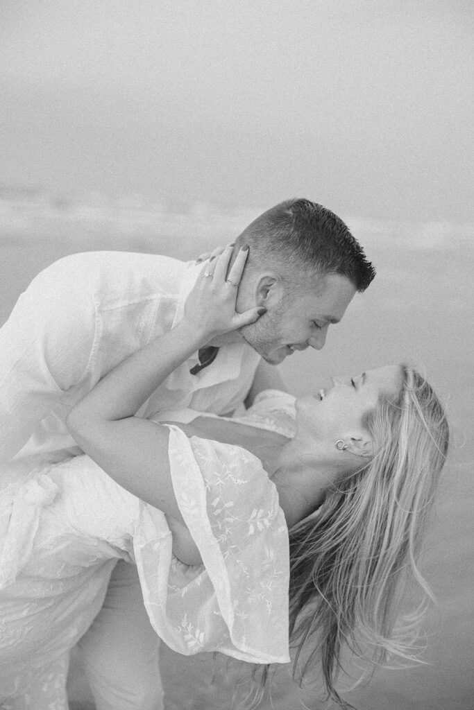 couple smiling during engagement sesison on the beach in texas