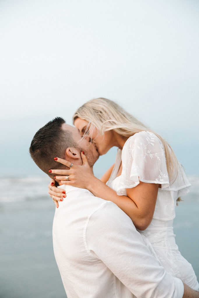 couple kissing during engagement sesison on the beach in texas