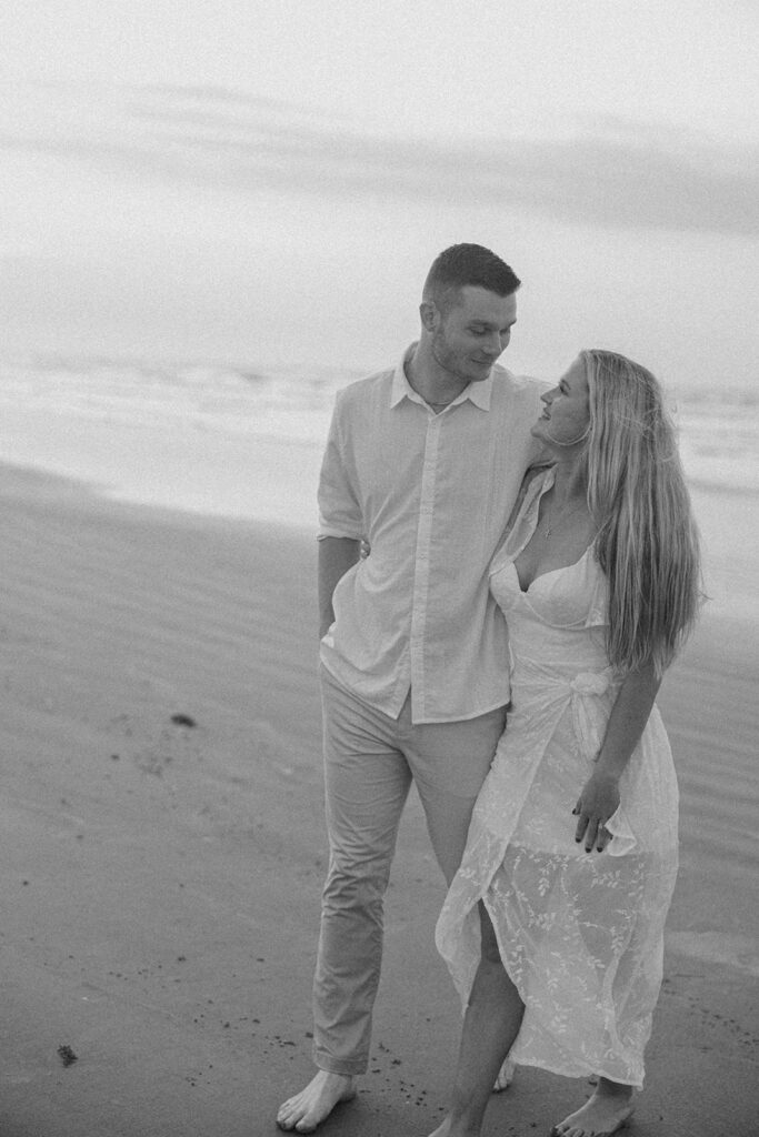 black and white candid couples photos walking on the beach