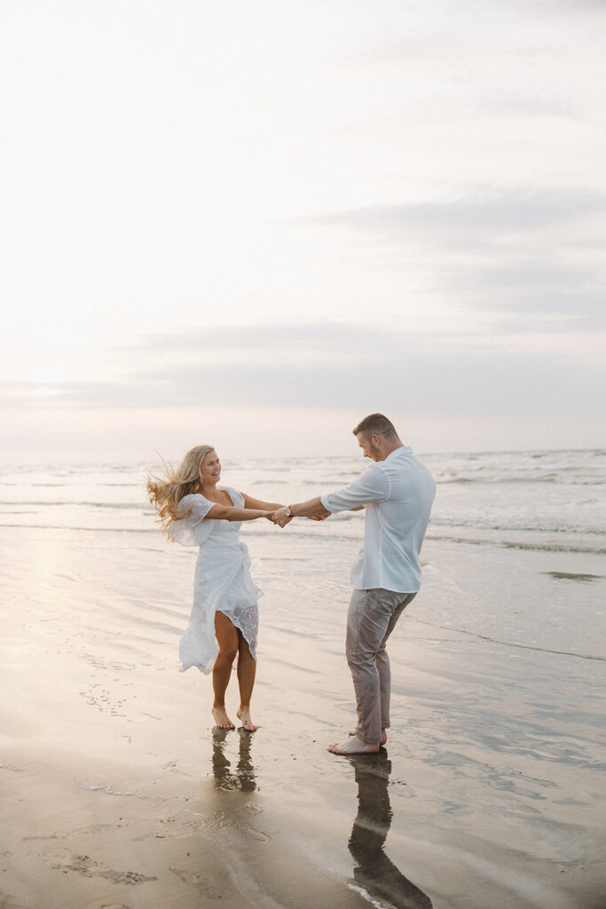 couple spinning pose on the beach