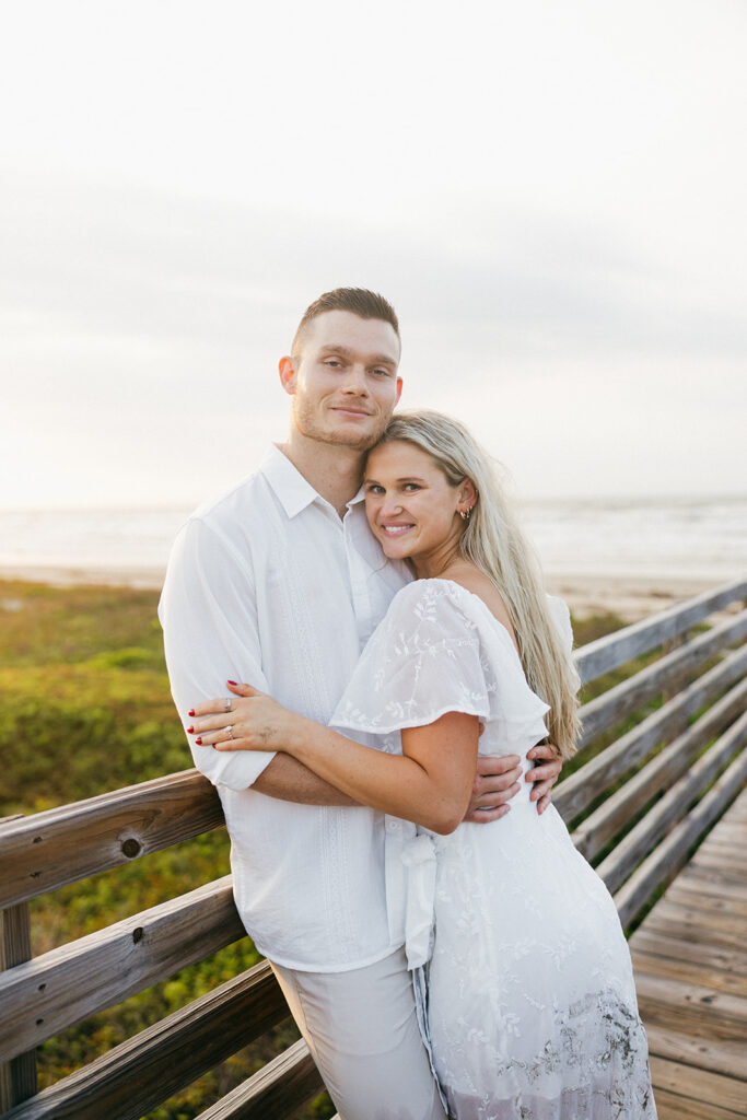 couple smiling on bridge for couples photoshoot