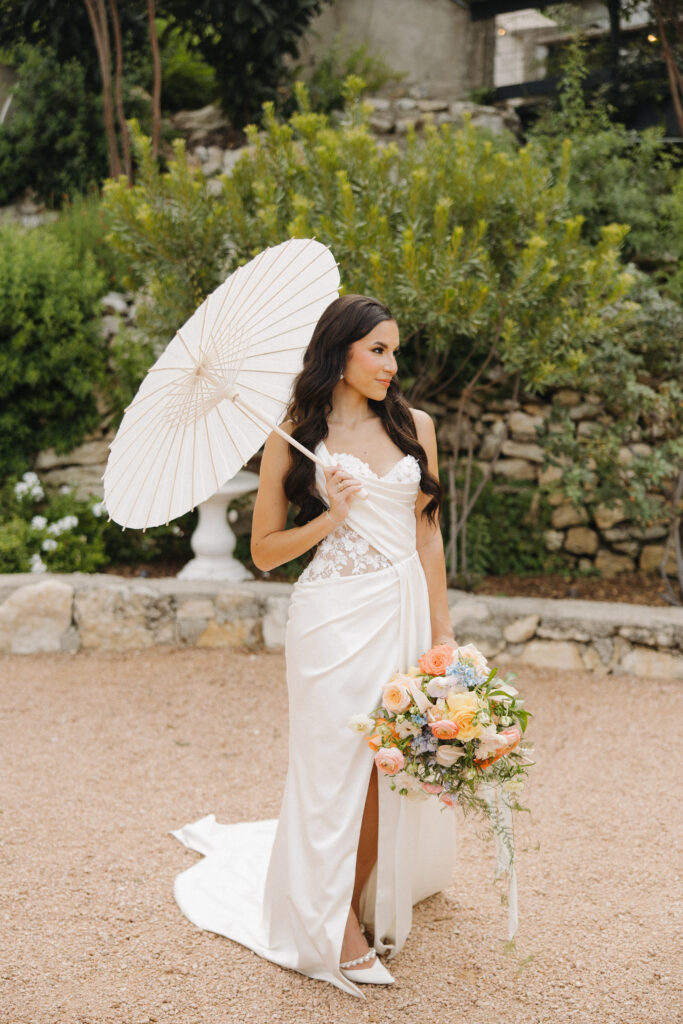 bride holding bouquet and umbrella for photos