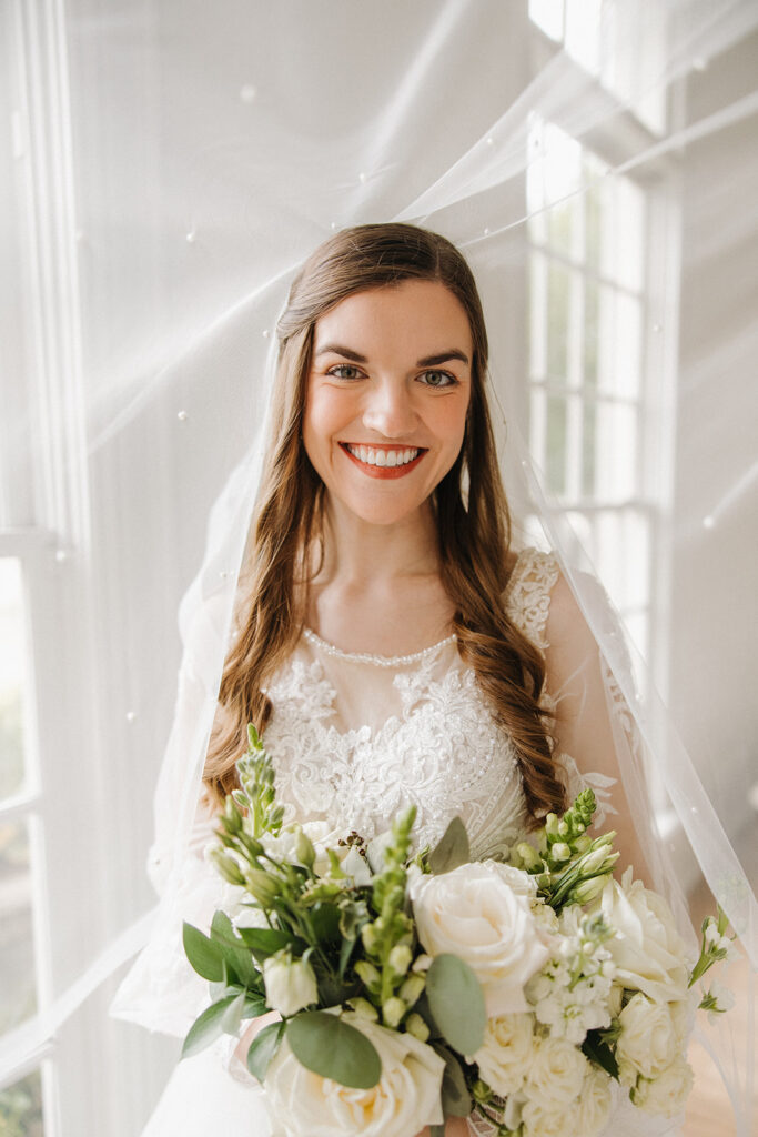 bride smiling underneath pearl detailed veil