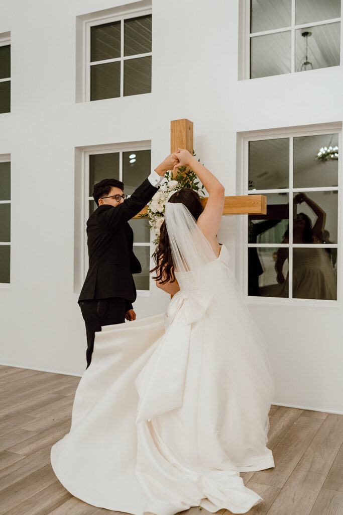 groom spinning bride pose at the altar