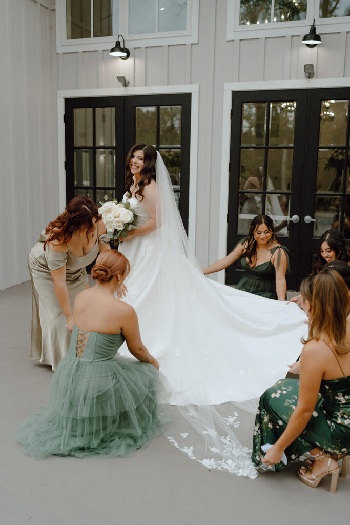 bridesmaids helping bride fix dress