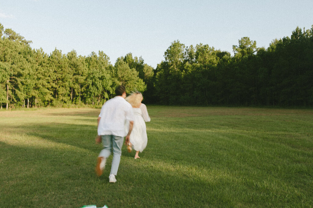 cinematic couples photoshoot running in a field