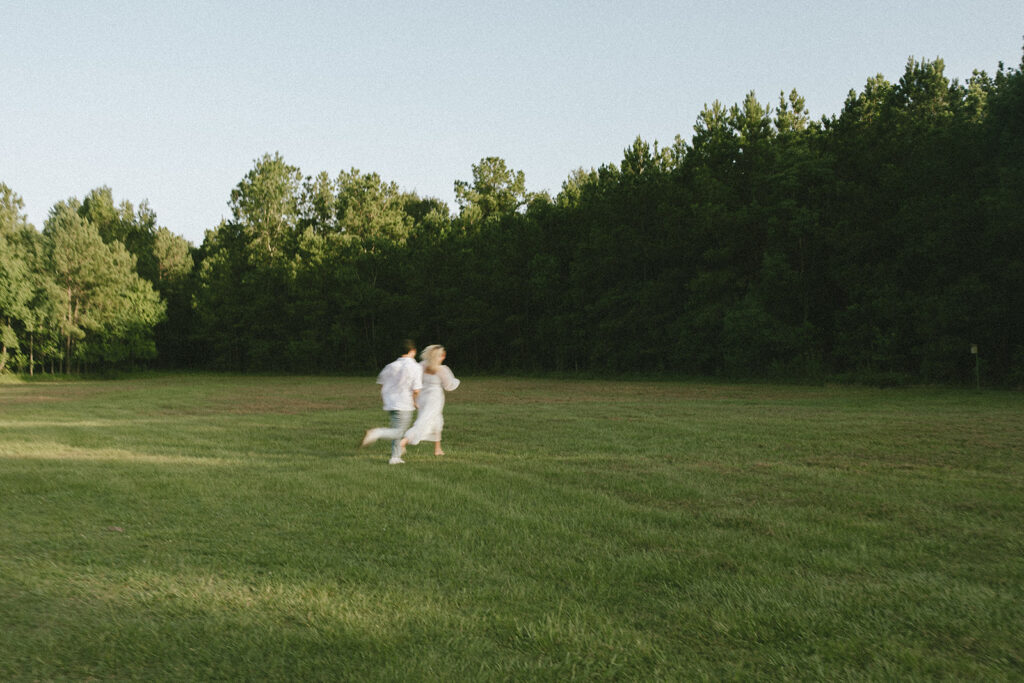 cinematic couples photoshoot running in a field