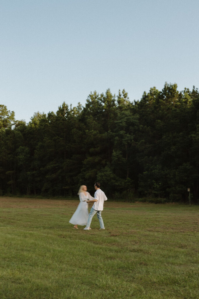 cinematic couples photoshoot running in a field