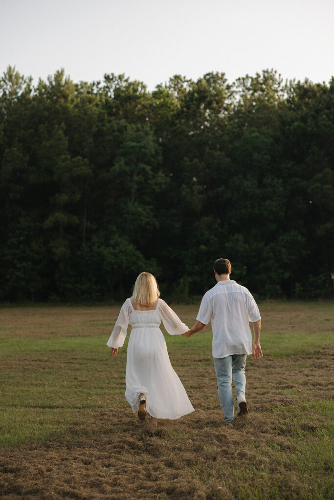 cinematic couples photoshoot running in a field