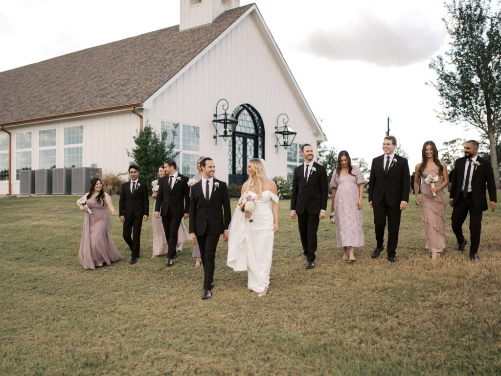 bridal party walking in front of texas wedding venue