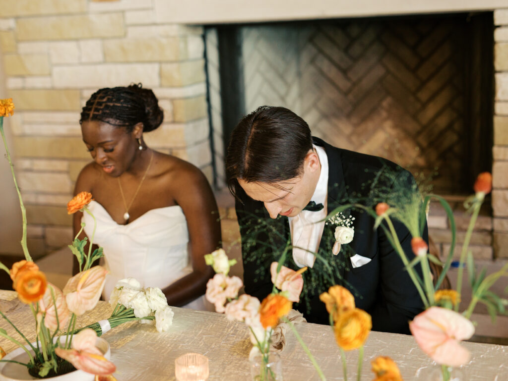 bride and groom praying at reception table