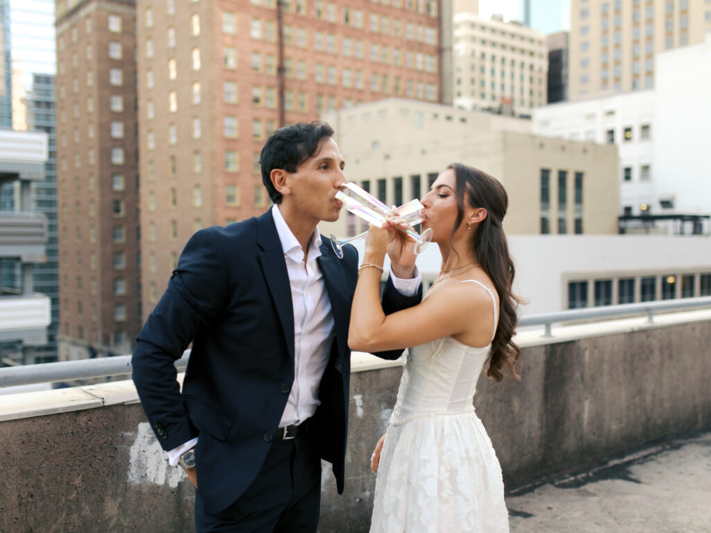 couple popping champagne during engagement session