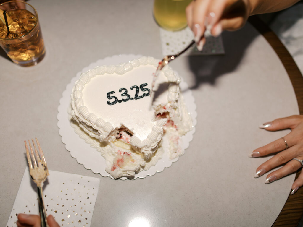 couple celebrating engagement with cake and drinks