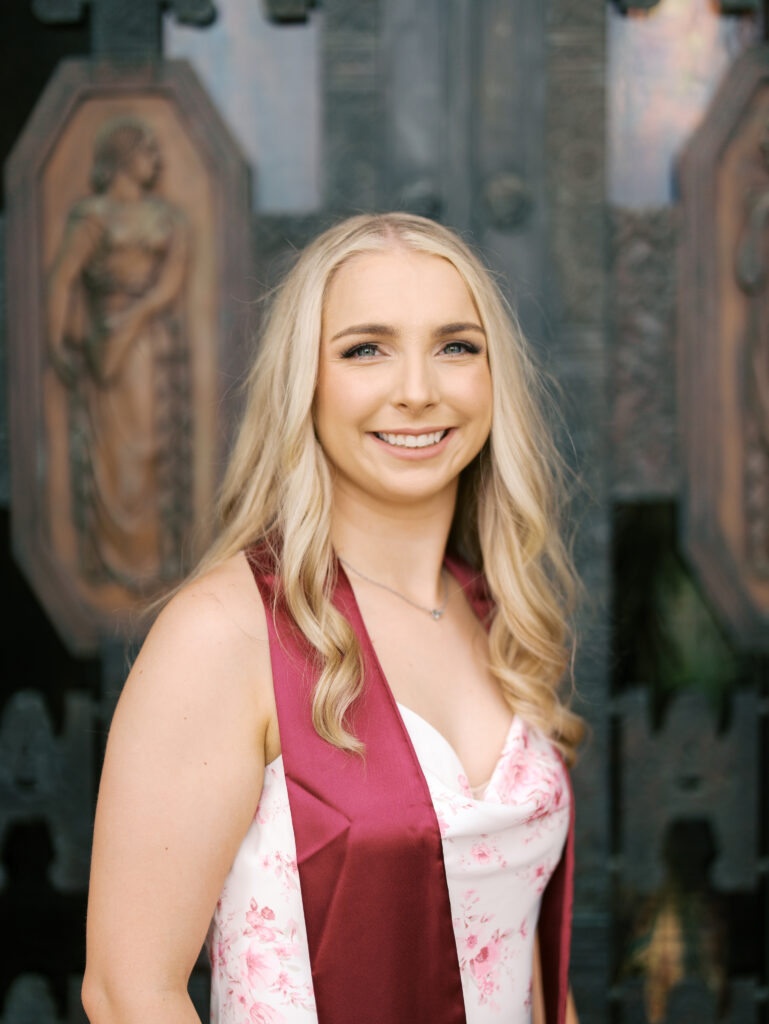 college senior smiling in her cap and gown