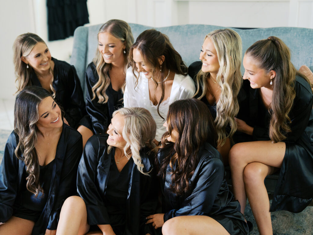 bride smiling and laughing with her bridesmaids in bridal suite
