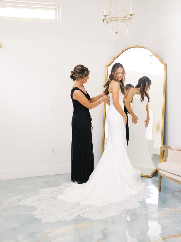 mother of bride helping bride get ready for ceremony