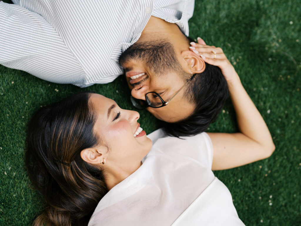 outdoor engagement photography couple laying in the grass