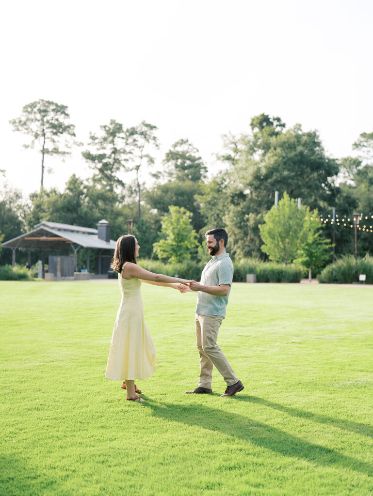 couple spinning and laughing at the park in houston