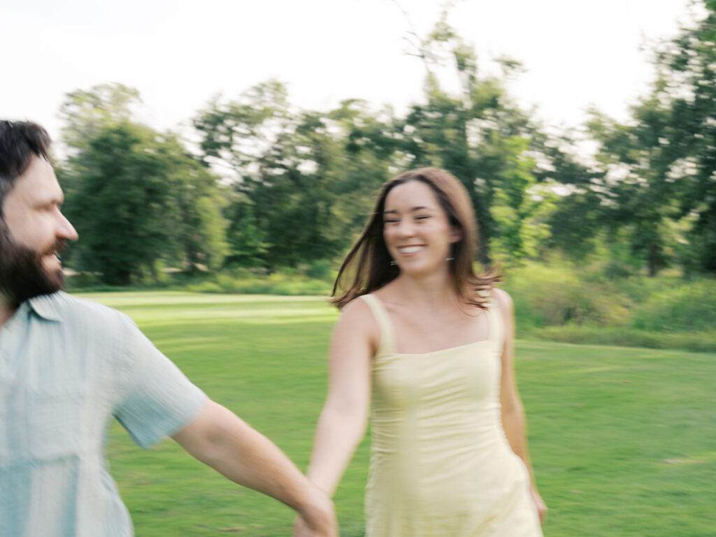 couple laughing and running at the park