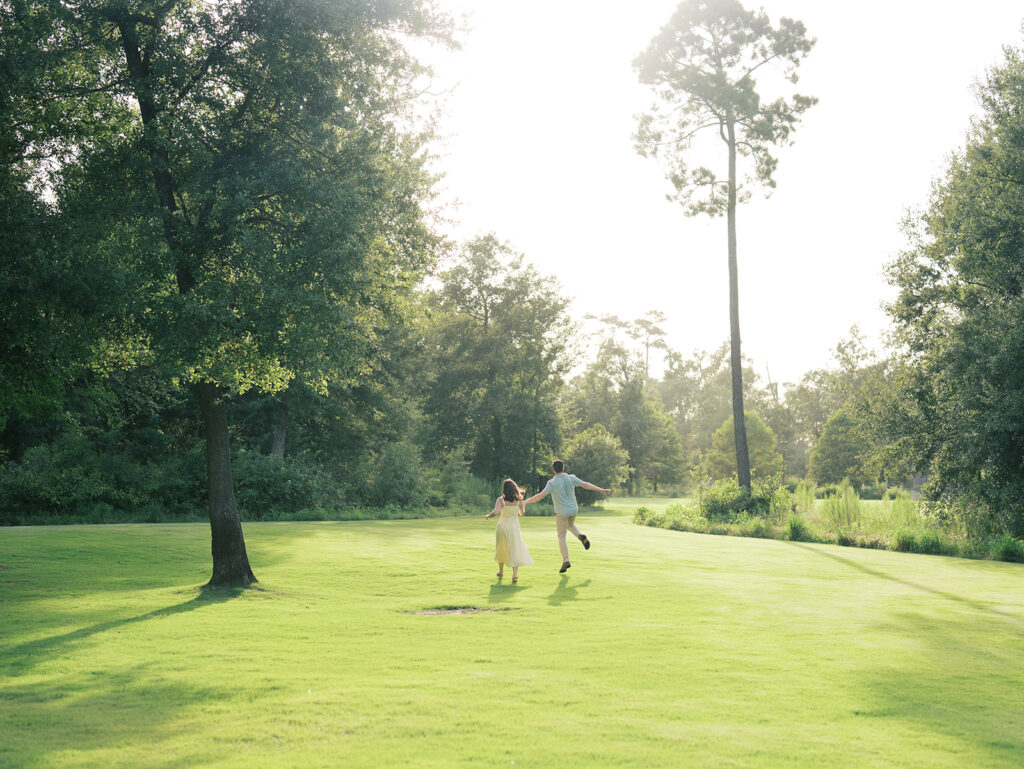 couple laughing and running with their dog
