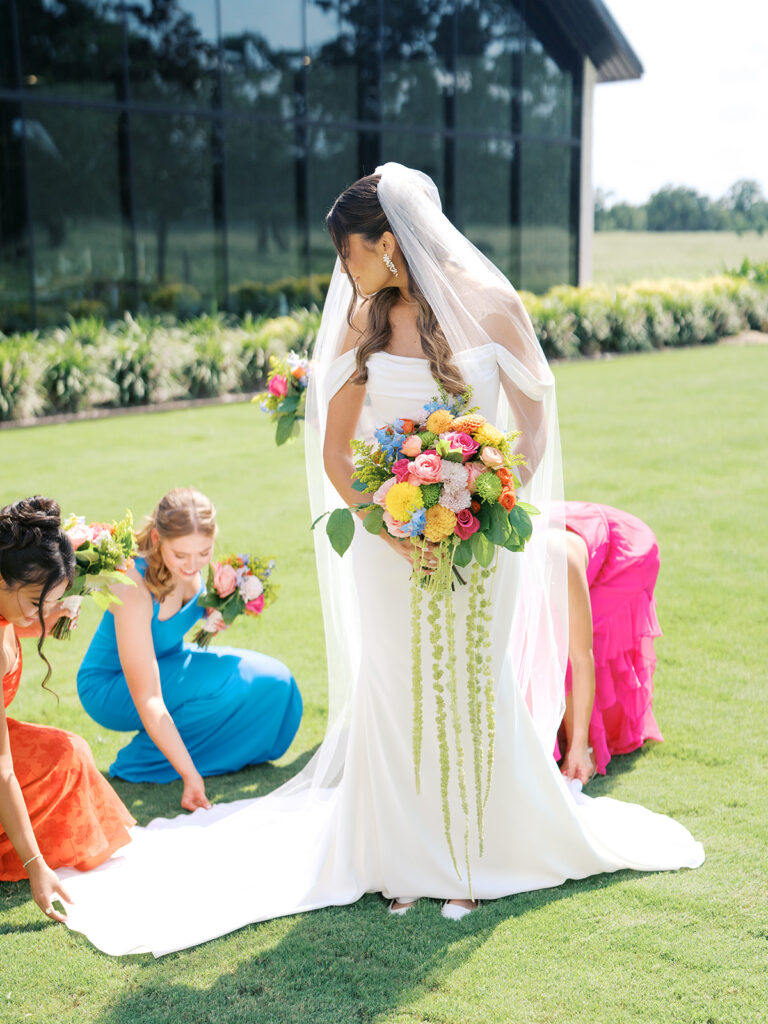 bridesmaids helping bride with dress train