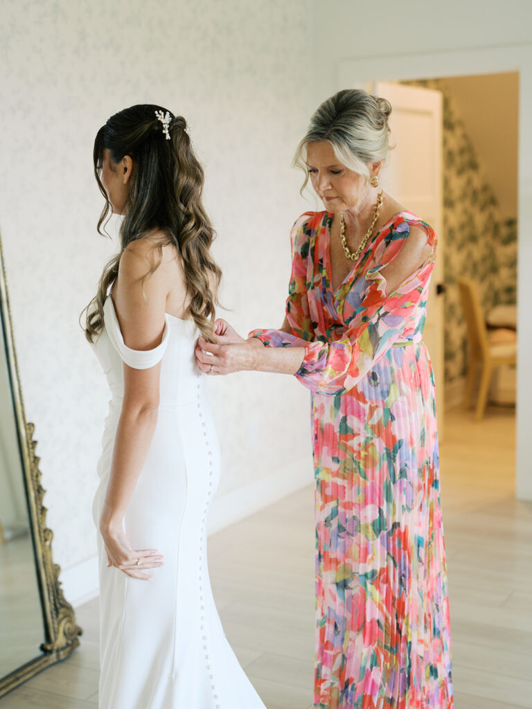 mom helping bride get ready for wedding
