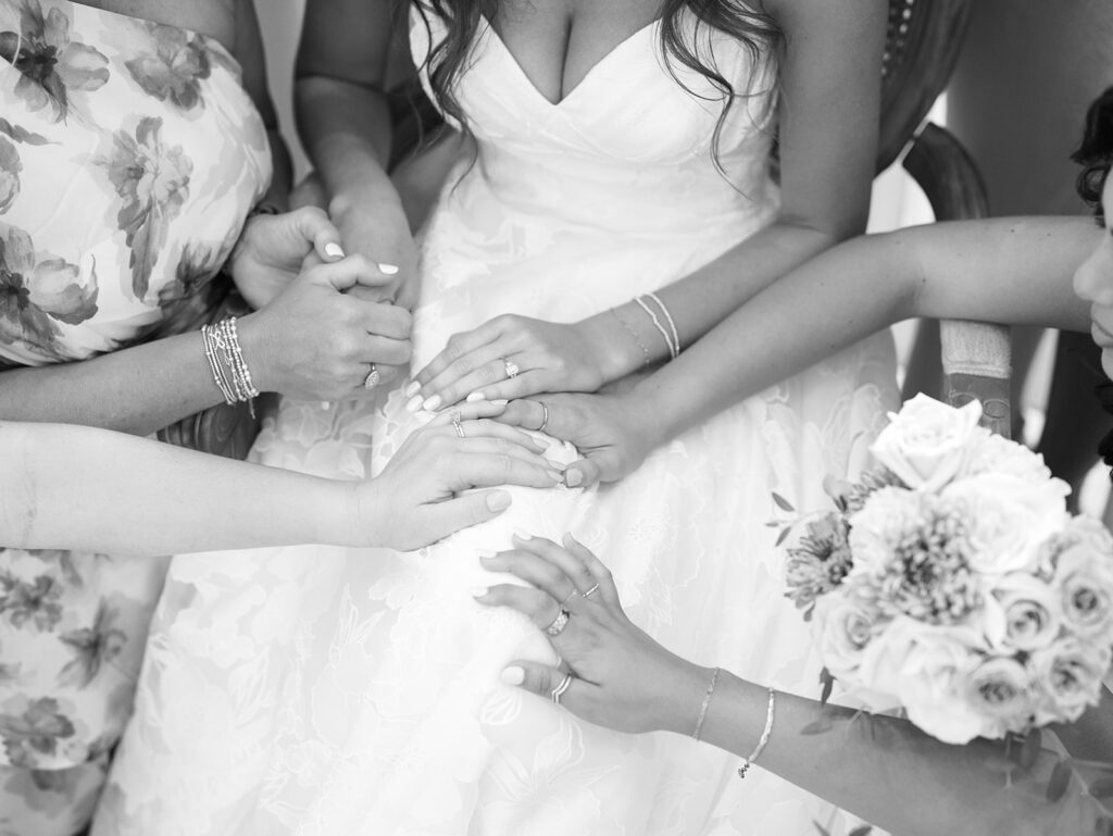 bridesmaids praying over bride