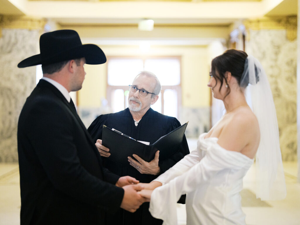 bride and groom getting married in the houston courthouse